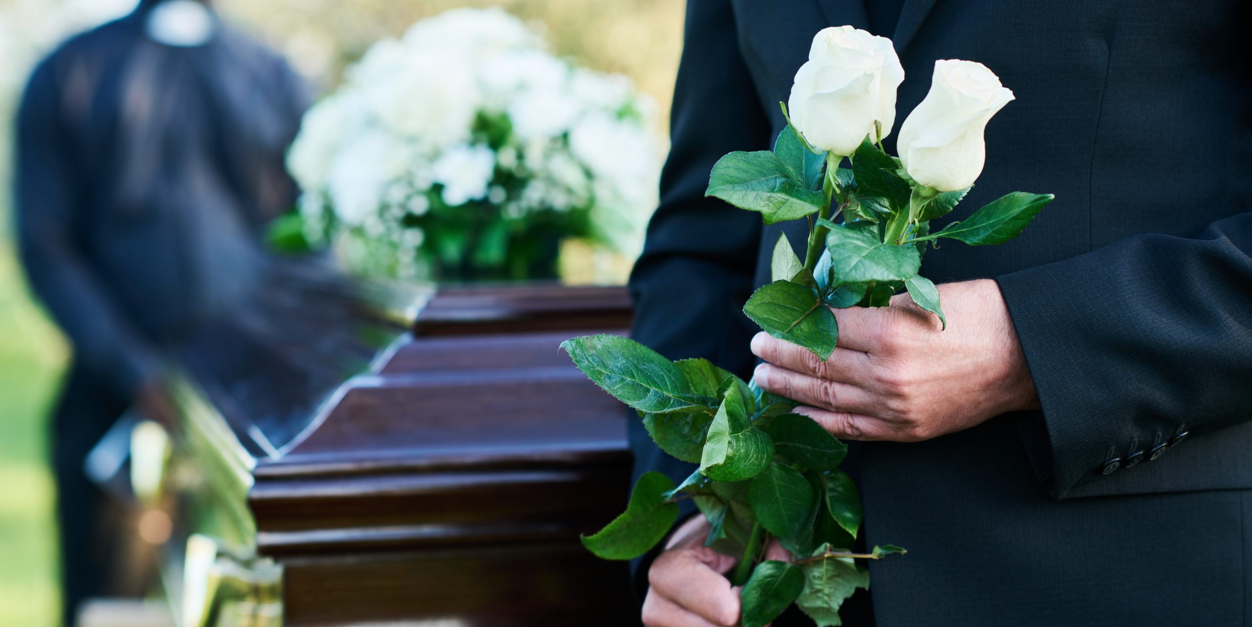 señor en un funeral sujetando unas flores